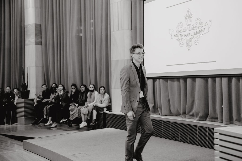 Keelan Heesterman walking on stage to receive his monetary prize for the Youth Parliament 2022 Competition sponsored by New Zealand Business & Parliament Trust